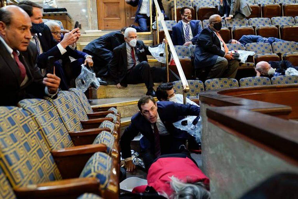 Fresno Democrat Rep. Jim Costa, above, clears the row ahead of him while Jason Crow, a Democrat from Colorado, stoops down as protesters try to break into the House Chamber at the U.S. Capitol on Wednesday, Jan. 6, 2021, in Washington.