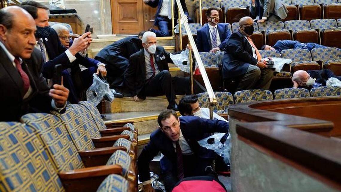 Fresno Democrat Rep. Jim Costa, above, clears the row ahead of him while Jason Crow, a Democrat from Colorado, stoops down as protesters try to break into the House Chamber at the U.S. Capitol on Wednesday, Jan. 6, 2021, in Washington.