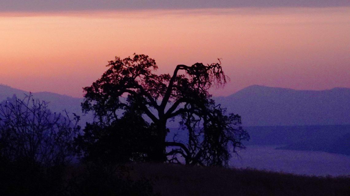 The Valley sky turns orange at dusk from the smoke of the KNP Complex fire bur, seen from Highway 198 at Lake Kaweah Thursday, Sept. 30, 2021 near Three Rivers.