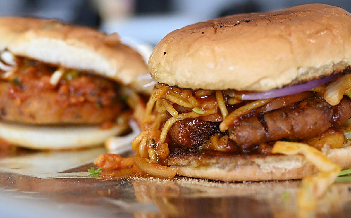 Vegetarian burgers including the popular Aloo Tikki Noodle Burger to the right, served at Rangla Punjab Restaurant & Sweets Friday, Oct. 17, 2025 in Fresno.