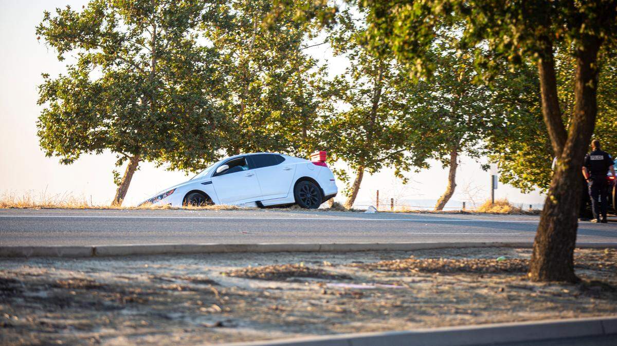A car sits on the shoulder of southbound Friant Road south of Copper Avenue after its driver was shot on Sunday, July 26, 2020.