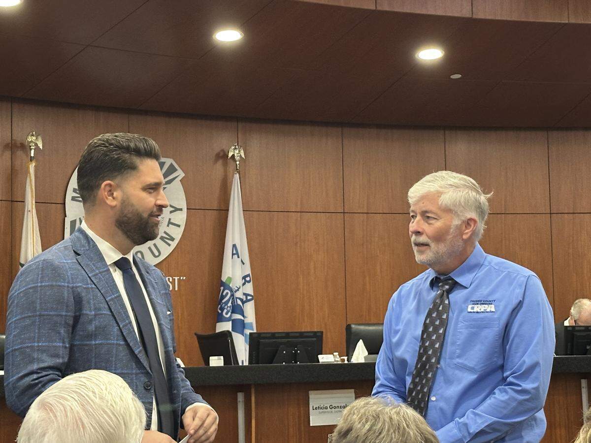 Madera County District 1 Supervisor Jordan Wamhoff speaks to Mike Carey, of the Fresno County chapter of the California Rifle and Pistol Association, before a Board of Supervisors meeting in Madera on Tuesday, Oct. 21, 2025.