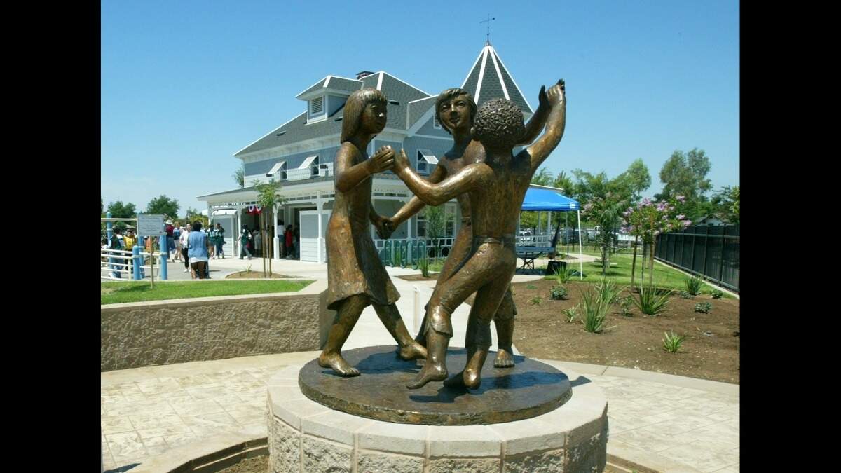 A statue of children playing looks out to the new Trolley Creek Park built by the Fresno Metropolitan Flood Control District on three-acres at a cost of $1.7 million located at Huntington and Helm in Fresno on Friday, July 9, 2004.