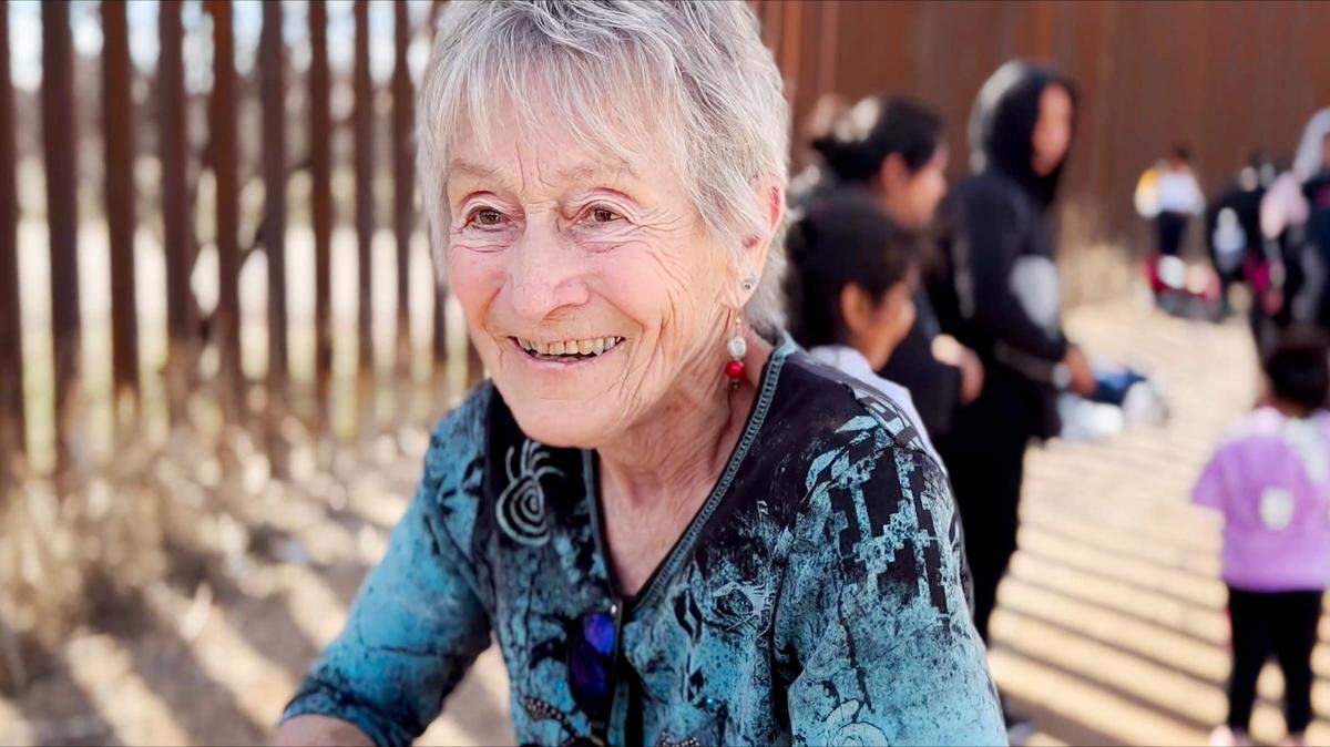 Fotograma cedido por Love Project Films donde aparece la budista judía, de 82 años, Shura Wallin, cofundadora del grupo humanitario Samaritanos de Green Valley, ayudando a los migrantes que cruzan la frontera de Arizona.