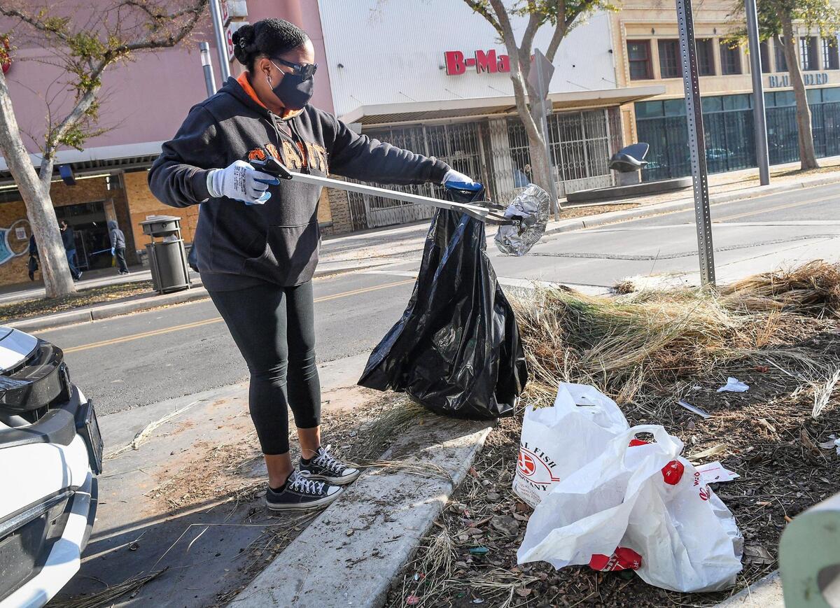 Rochelle Butler of Fresno helps pick up trash on Fulton Street in downtown Fresno during one of two cleanup events as a part of Mayor Jerry Dyer’s new initiative, Beautify Fresno, to celebrate the National Day of Service on Martin Luther King Jr. Day, Monday, Jan. 18, 2021. About 200 volunteers signed up for the event to pick up trash in the Fulton District and the Lowell District to honor the legacy of the late Reverend King. On Martin Luther King Jr. Day residents are encouraged to use the holiday as “a day on, not a day off” and look for ways to volunteer to make their communities better.