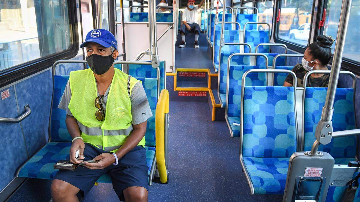Yonas Paulos, left, of Fresno, takes a seat on a Fresno Area Express bus in downtown Fresno, on Friday, Aug. 28, 2020. Paulos is visually impaired and relies on buses to get to his medical appointments. He is concerned about catching the coronavirus while riding the bus or at a stop with too many people.