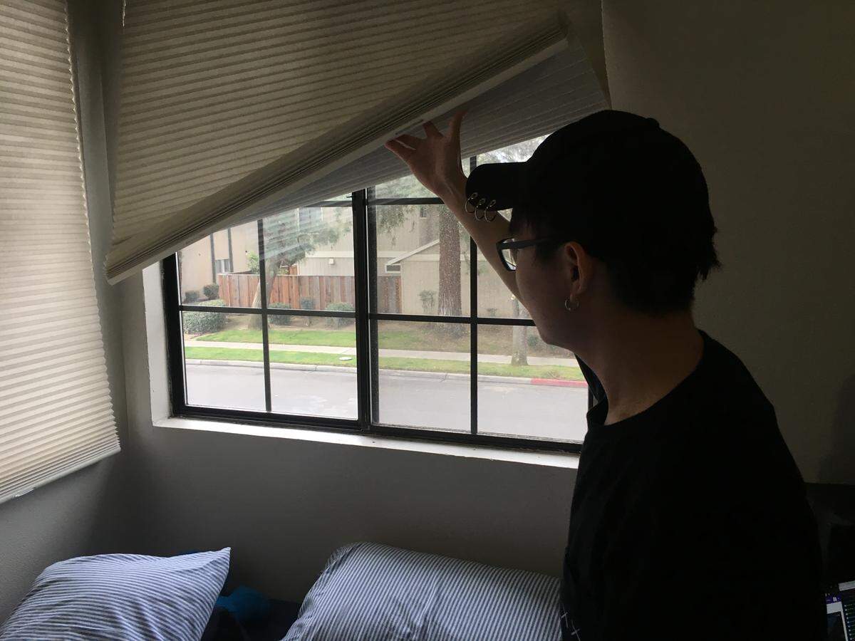 Eric Gan, 20, looks out the window from his room in a northeast Fresno apartment. A shooting on Sunday, March 3, 2019, sent bullets flying into his apartment.