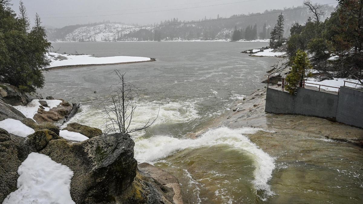 Fresh mountain snowmelt flows from Willow Creek into Bass Lake in Madera County during a rainstorm on Tuesday, March 14, 2023.