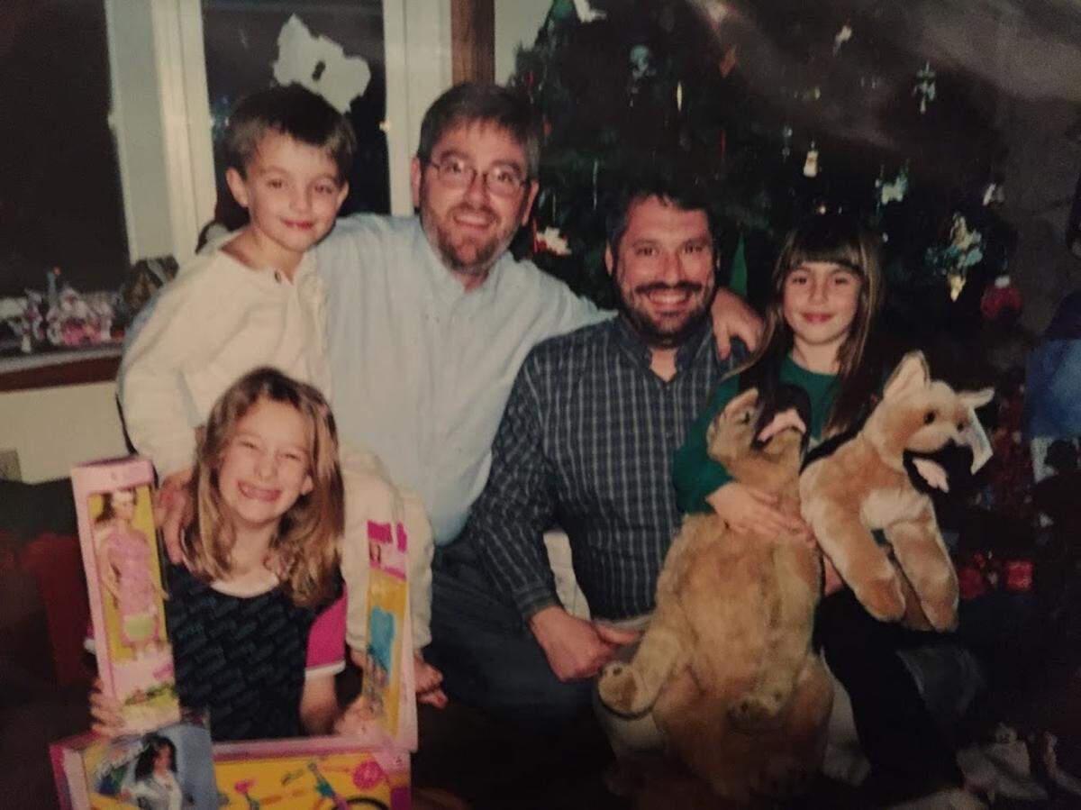 In this undated photo, Tara O’Sullivan, far right, during Christmastime as a child, clutches two stuffed dogs gifted to her by her godparents, center. O’Sullivan’s love of dogs, people, and police have propelled her family to create a GoFundMe campaign to purchase a K-9 officer for the Sacramento Police Department in her honor.