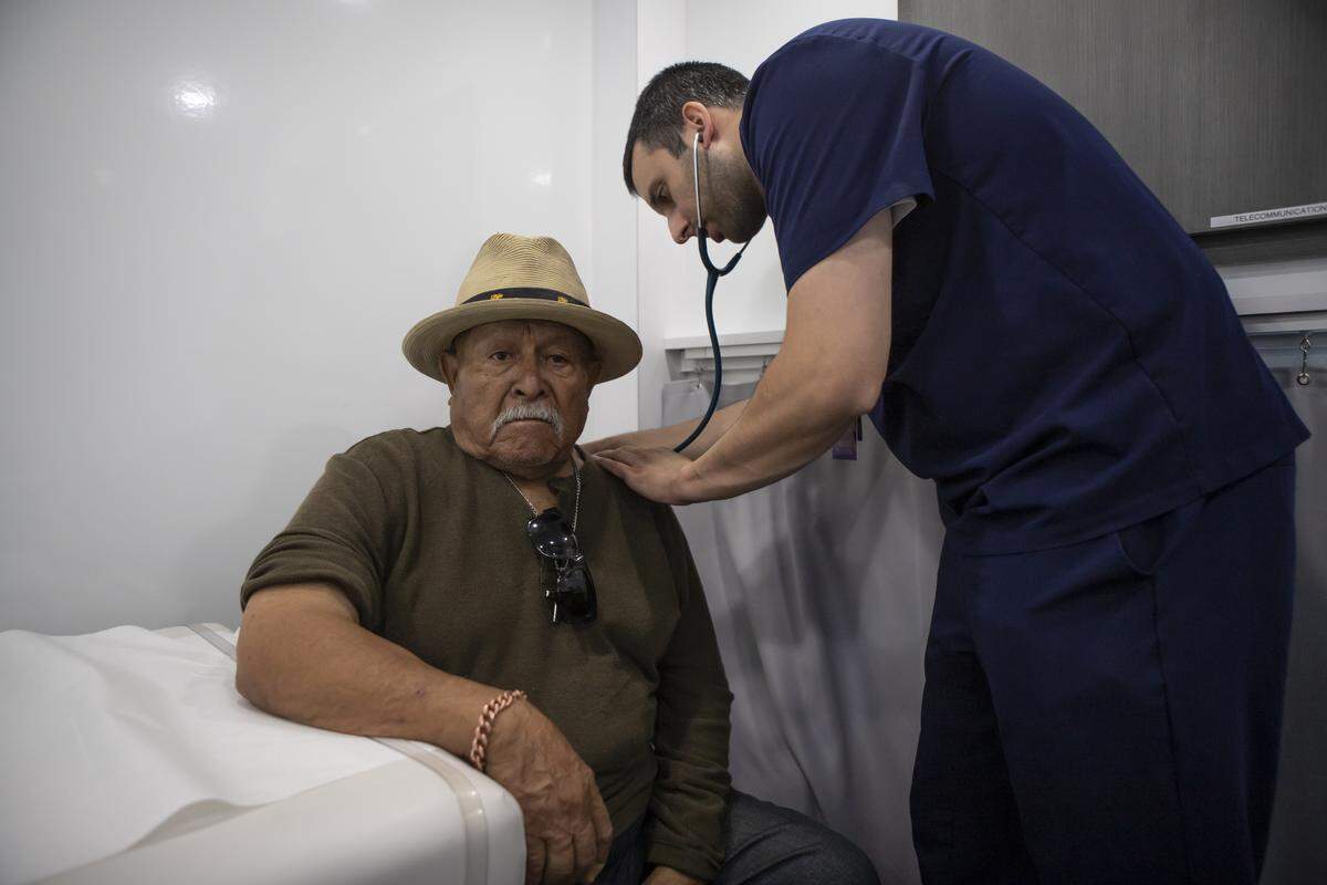 Patient and Parlier resident Javier Hernandez getting his blood pressure and blood sugar test during a check-up at the Saint Agnes Mobile Health Unit mobile clinic parked in the City Heritage Park parking lot in Parlier on May 16, 2025. Photo by Larry Valenzuela, CalMatters/CatchLight Local
