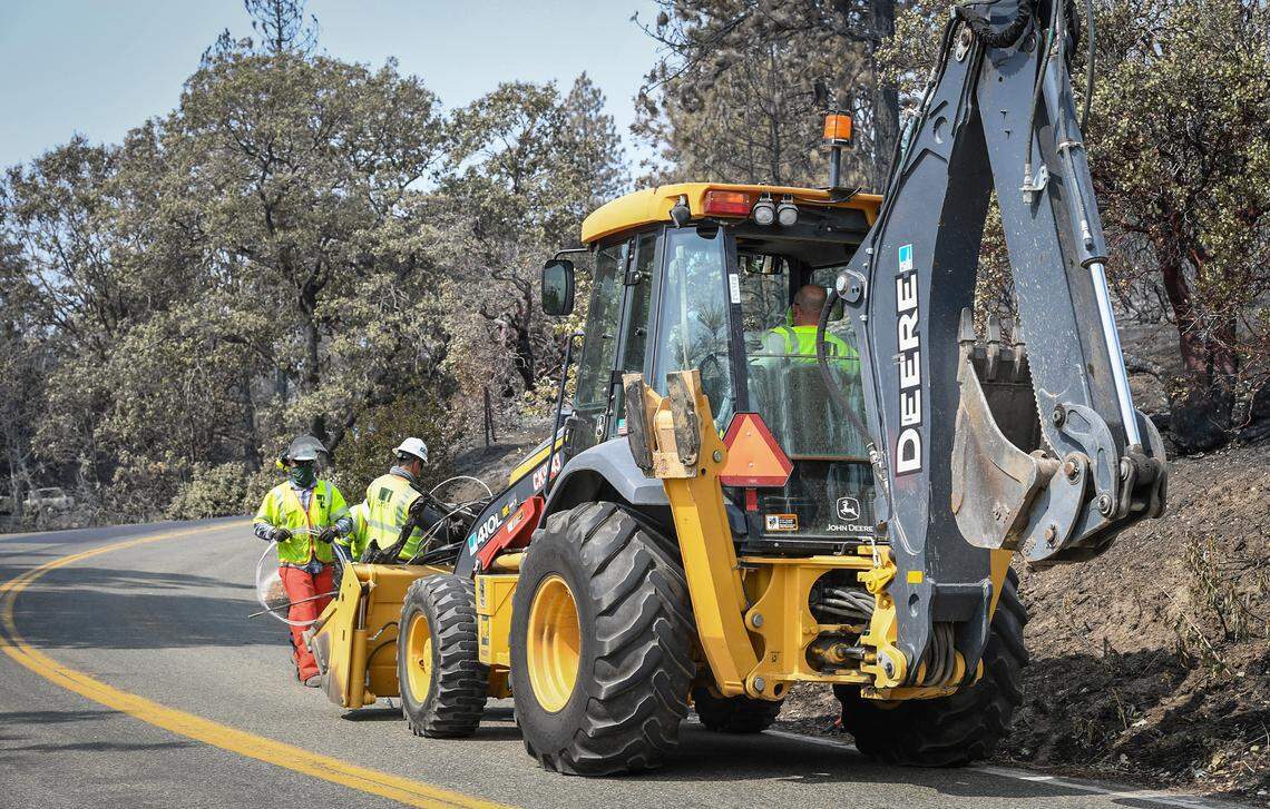 Crews work to removed downed power lines along Auberry Road in the evacuation zone at Pine Ridge on Saturday, Sept. 19, 2020.