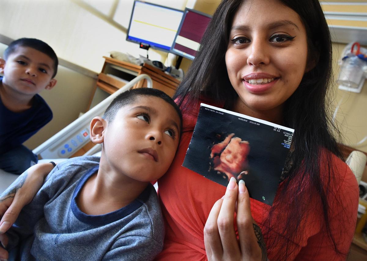 Recovering in her hospital room Friday morning with her sons Naithen Rivera, 5, center, and Adriel Arizpe, 4, left, by her side, Ketxaly Maldonado shows the ultrasound image taken last month of her daughter Jacquelyn, who was born Wednesday at Community Regional Medical Center during a complicated surgery.