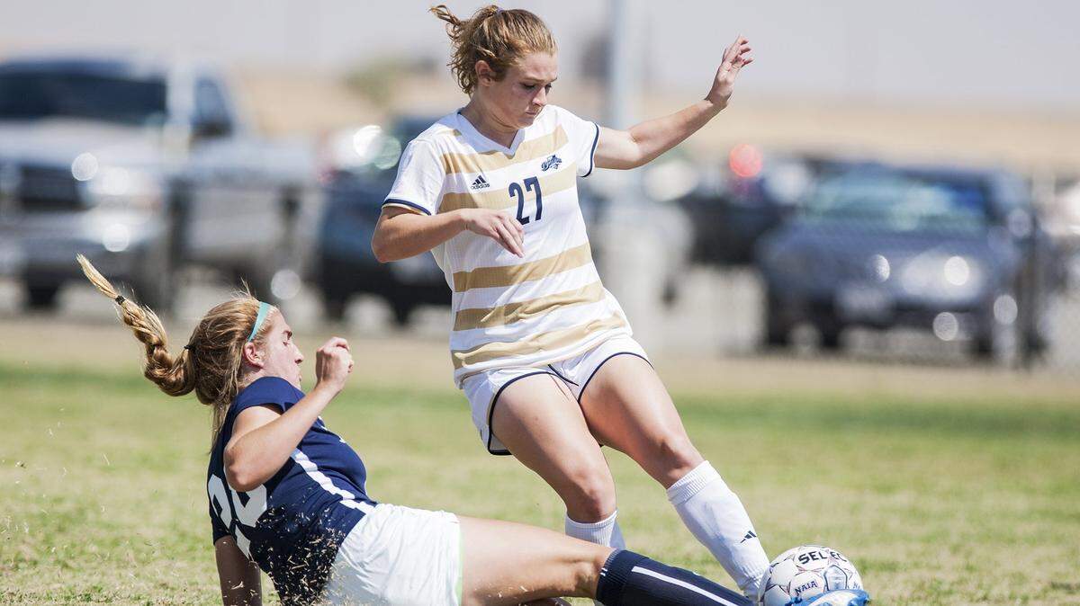 University of California, Merced sophomore Tori Mollard (27) attempts to get past Hope International University’s Hannah Williams (28) during a game at UC Merced in Merced, Calif., Thursday, Sept. 8, 2016.