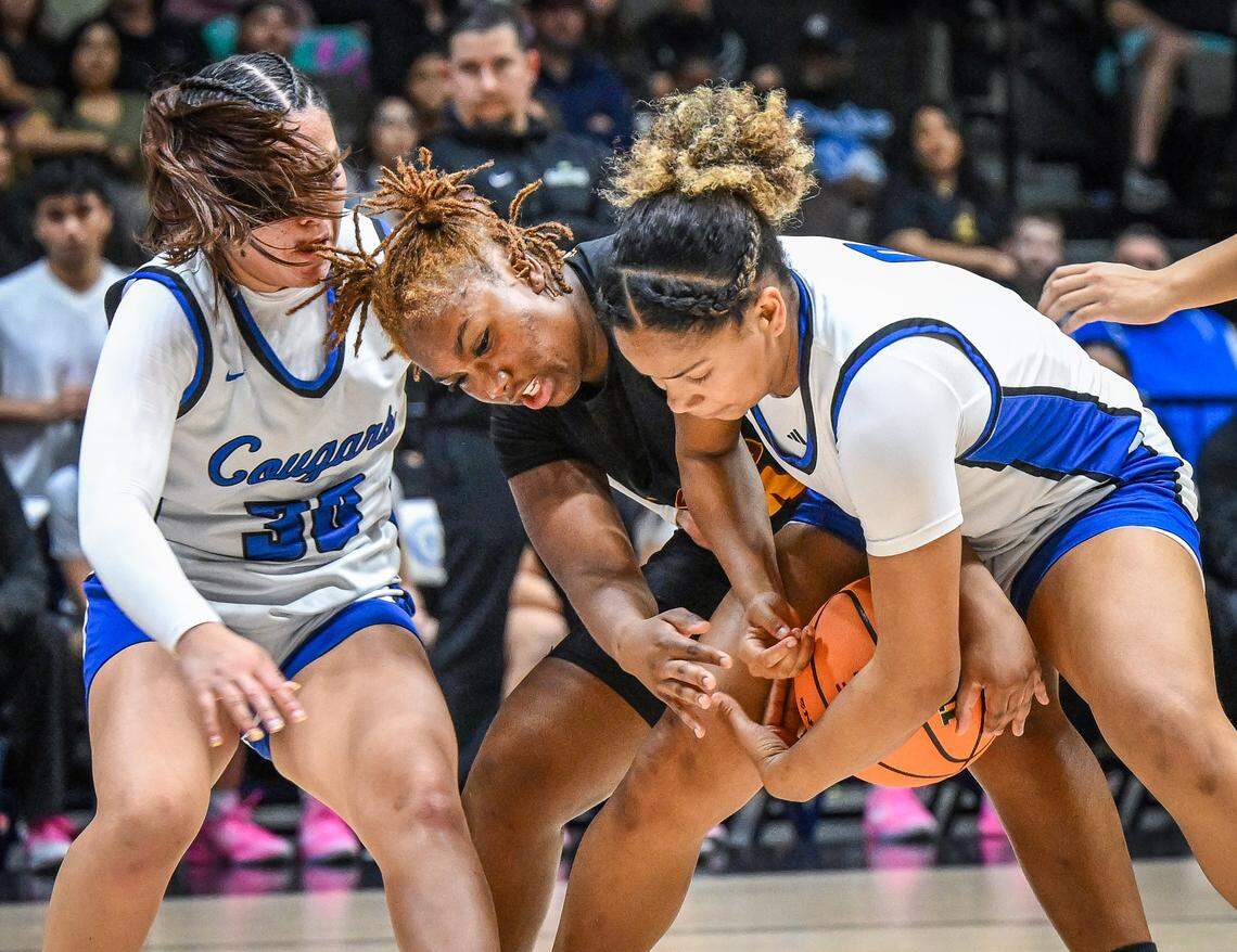 Clovis West's Ziane Williams, center, tries to grab the ball away from Clovis' Jada Walton as Yazmin Aguilera tries to screen her out during their Central Section Division 1 girls basketball championship game at Selland Arena on Saturday, Feb. 28, 2026. 