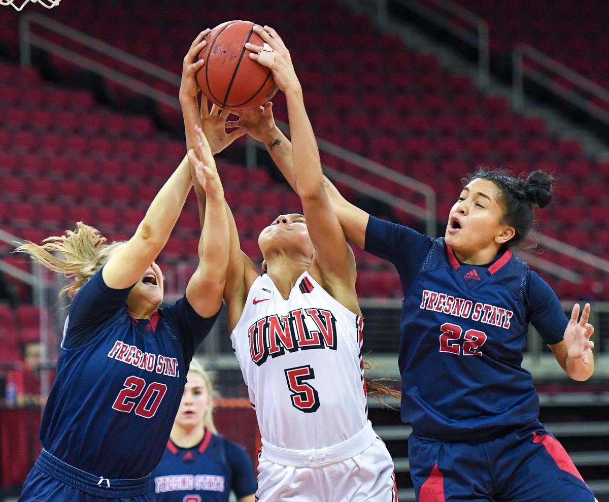 Fresno State’s Bree Delaney, left, and Aly Gamez, right, lose a rebound to UNLV’s Jade Thomas during their game at the Save Mart Center on Saturday, Feb. 27, 2021.