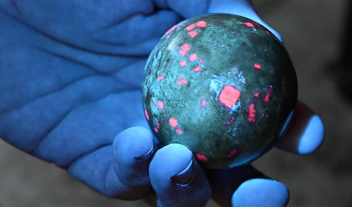 Fresno State physics professor Ray Hall has a wide collection of items that demonstrate physics as well as natural phenomena like a UV light revealing ruby in a kyanite matrix. Photographed Thursday, June 5, 2025 in Fresno.