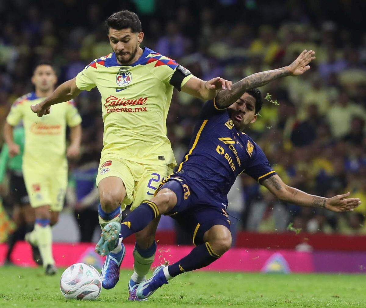 Henry Martín (i) de América, disputa el balón con Javier Aquino (d) de Tigres hoy, durante el juego de vuelta de la final del torneo mexicano de fútbol, entre América y Tigres en el Estadio Azteca de la Ciudad de México.