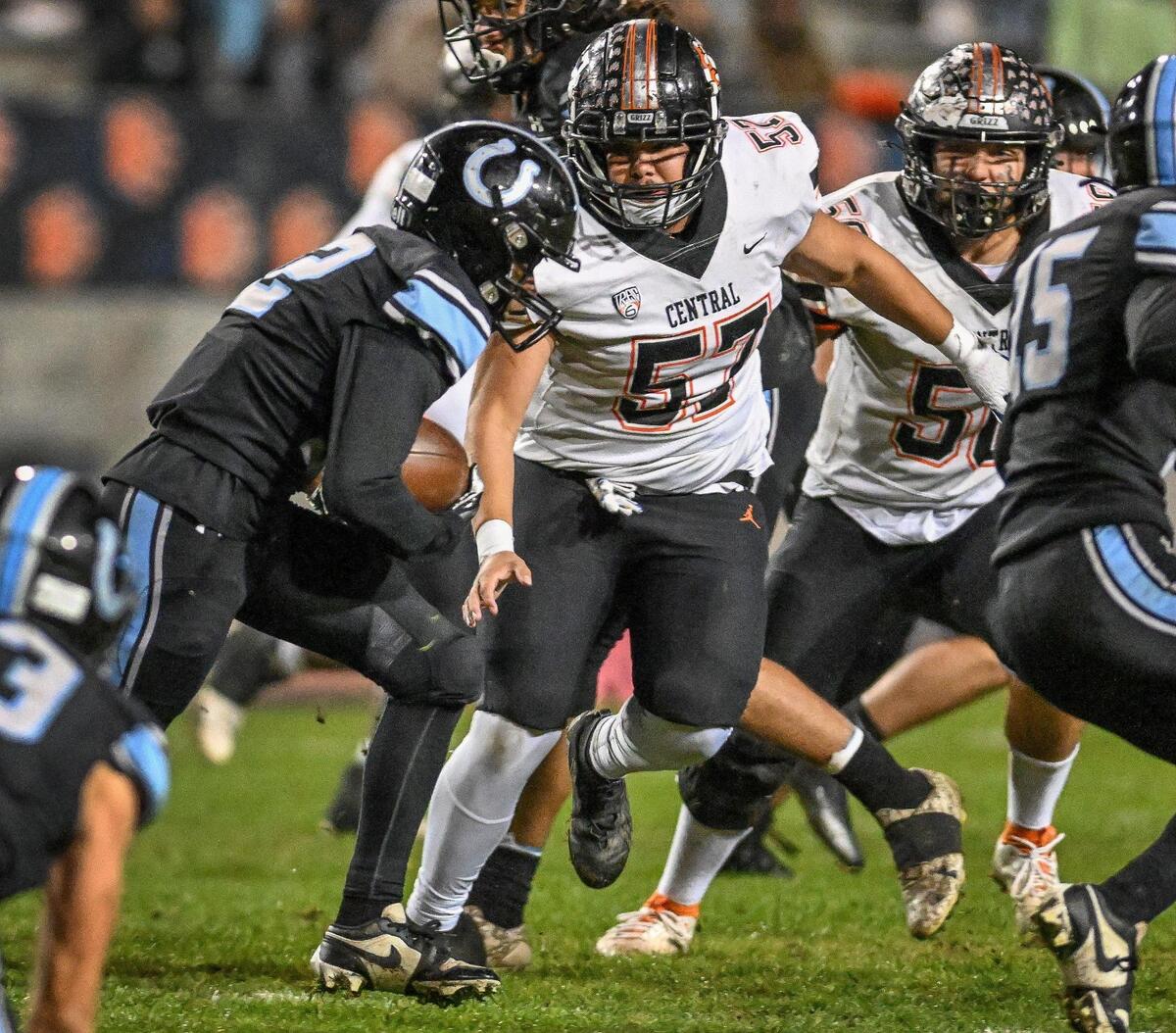 Clovis North’s Mon’Trell Beasley, left, takes the ball on a late-game interception against Central in their Central Section Division 1 football championship game at Veterans Memorial Stadium in Clovis on Friday, Nov. 24, 2023.