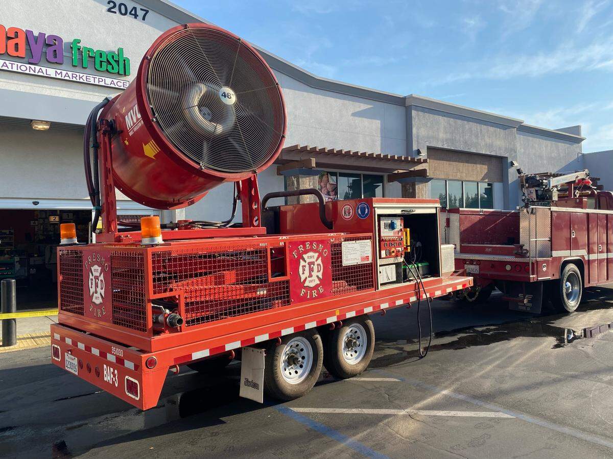 The Fresno Fire Department used a large fan to blow smoke out of a building during a two-alarm commercial fire in southwest Fresno on Tuesday, July 12, 2022.