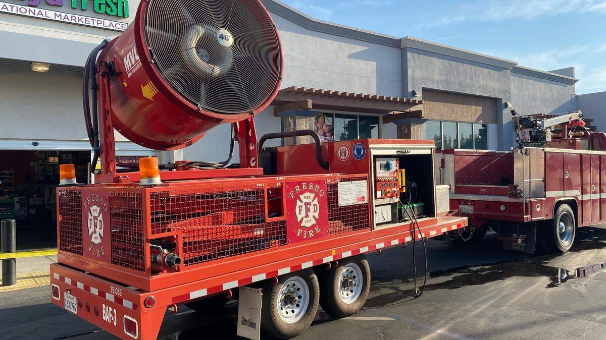 The Fresno Fire Department used a large fan to blow smoke out of a building during a two-alarm commercial fire in southwest Fresno on Tuesday, July 12, 2022.