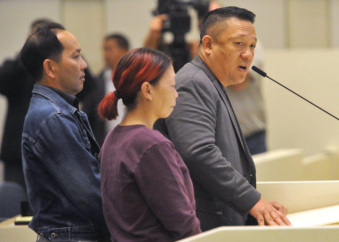 Pao Yang, executive director of The Fresno Center, right, with speaks, accompanied by Sang Vang, father of Pia Vang, left, and Soua Yang, center, wife of Kou Xiong, both victims in Sunday night’s shooting that left four dead, during a special council meeting where $40,000 reward money was pledged by the city, Friday morning, Nov. 22, 2019, at City Hall.