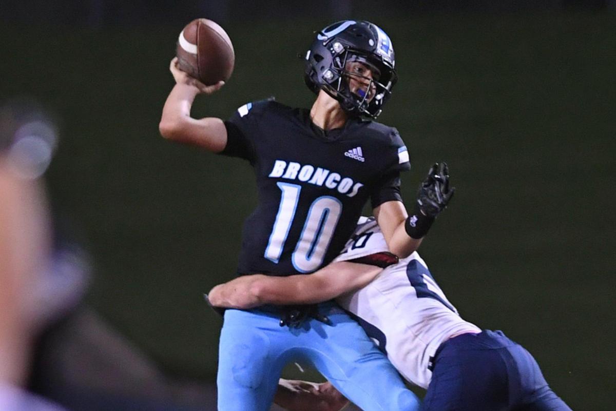 Clovis North quarterback Mario Cosma, left, manages to complete a pass as he’s hit by Central Valley Christian’s Trent Greidanus, right, in second half action Friday, Sept. 9, 2022 in Clovis. CVC won the nonleague game 23-9.