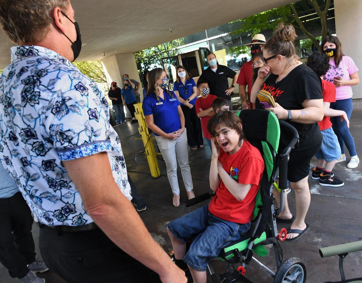 Valerie Vichorek, mother of 13-year-old Brennan Reny, wipes a tear as they’re greeted by RV Country president Curt Curtis, left, before he presents Brennan and his family the gift of a new travel trailer, through the company and its employees, and Make-A-Wish, Tuesday Aug. 17, 2021.