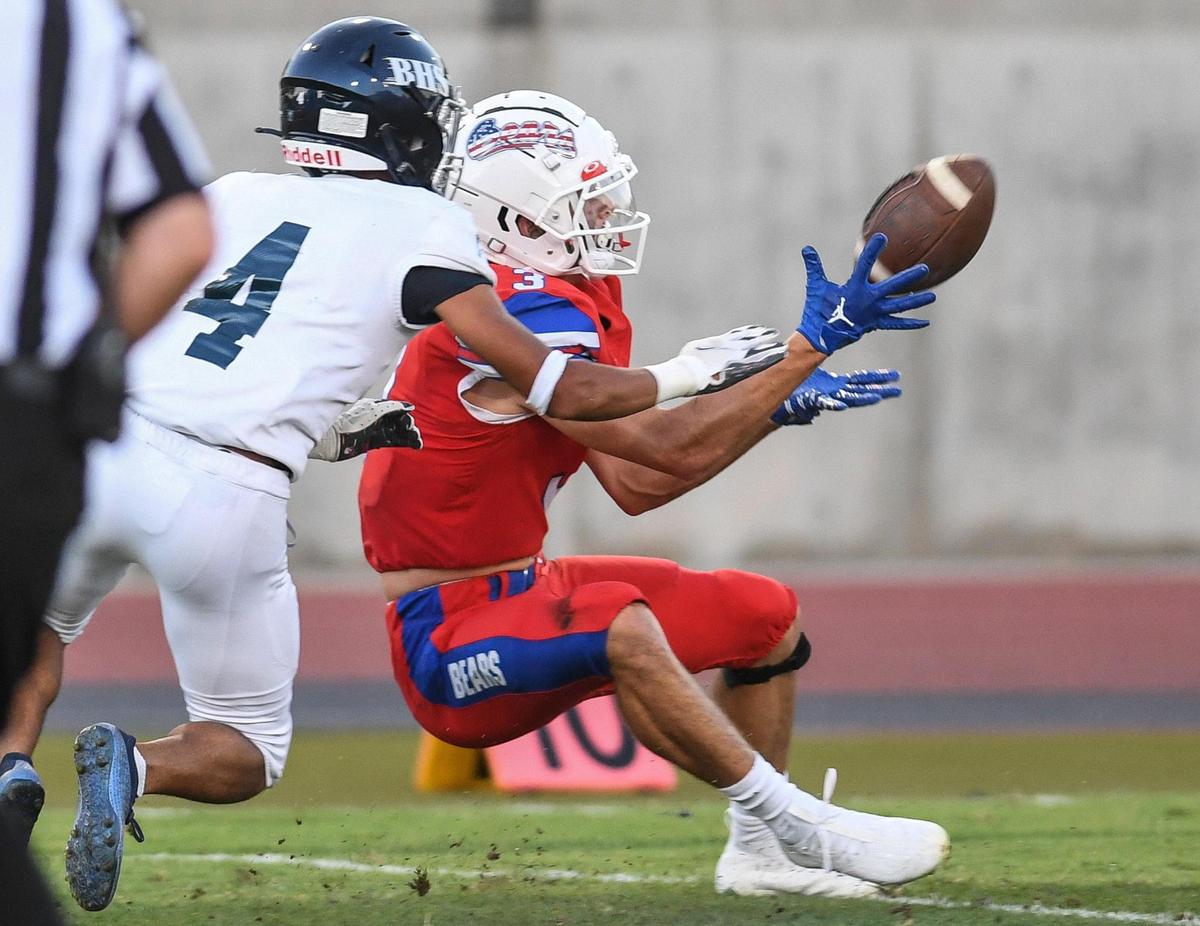 Buchanan’s McKay Jones, right, hauls in a long pass from quarterback Jayden Mandal in front of Bakersfield’s Bryson Campos in their game at Veterans Memorial Stadium on Friday, Aug. 19, 2022.