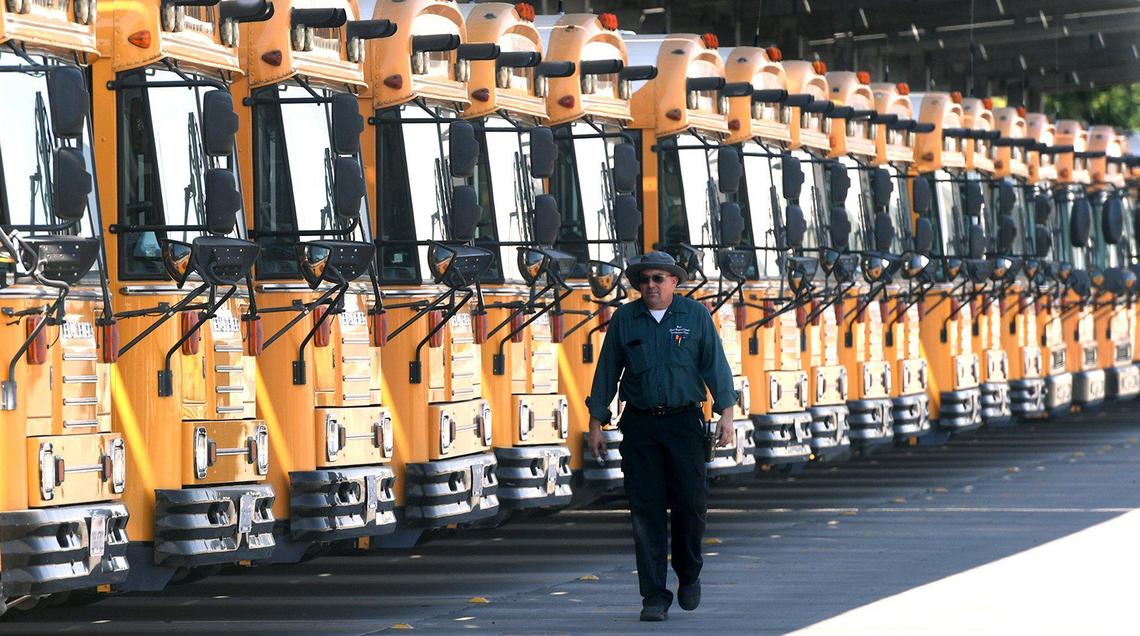 Brad Loutherbach, Clovis Unified mechanic, walks past a row of the district’s buses, August 5, 2021. Ahead of new school year, the district has been installing sanitization technology in buses, for disinfectant purposes as a Covid precaution. 75 buses have been outfitted with the system so far.
