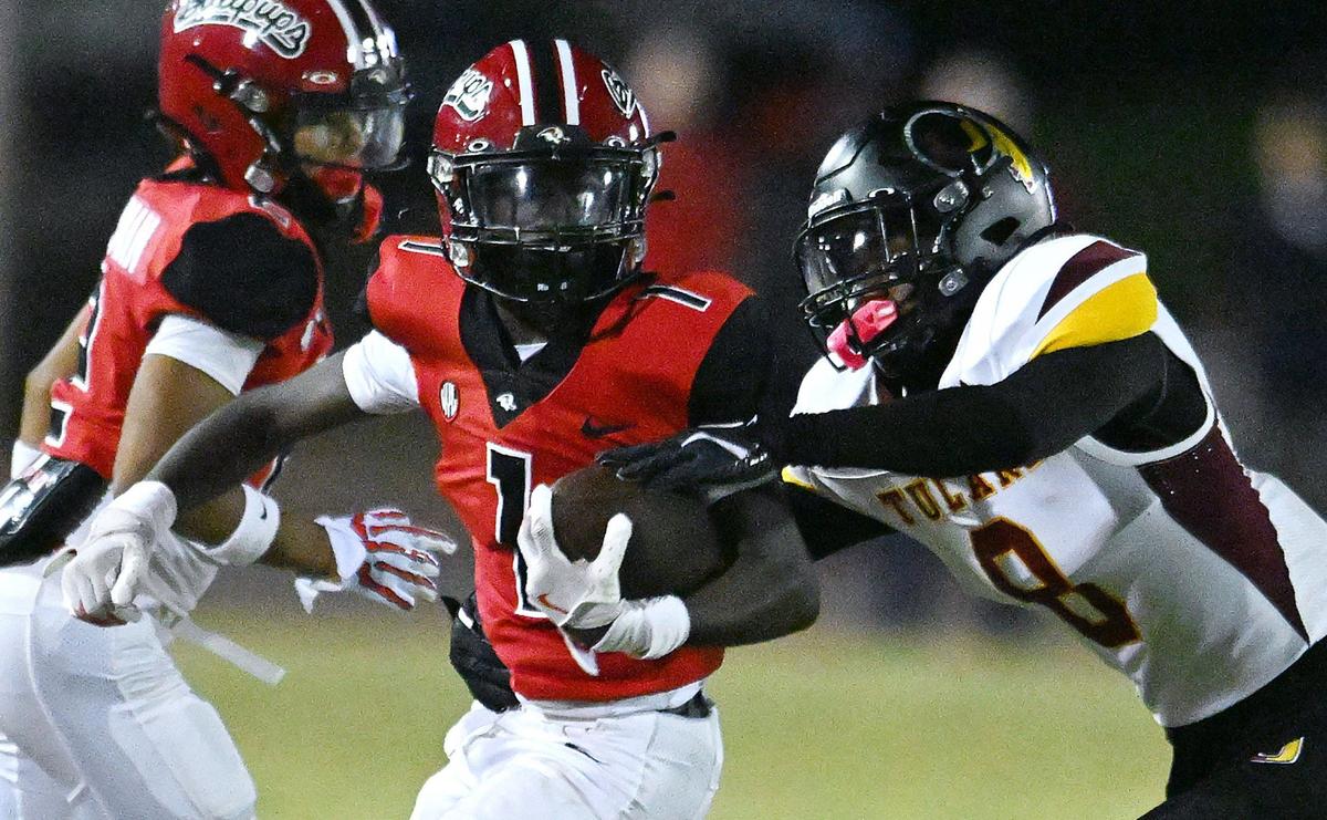 Hanford’ wide receiver Taveon Patterson, left, chased by Tulare Union’s Damian Williams, right, in second half action Friday, Oct. 11, 2024 in Hanford. Final score, Hanford 33, Tulare Union 8.