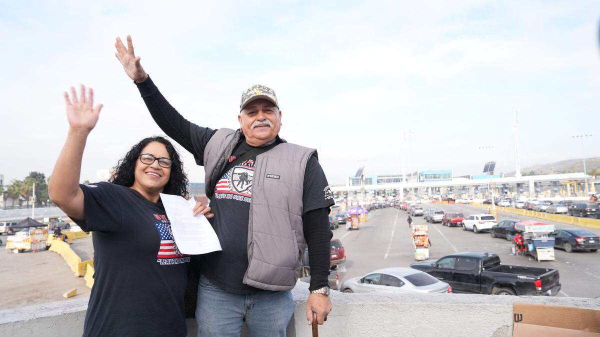 Héctor López Guillén, a U.S. Army veteran from Madera who was deported 17 years ago, waves on a border bridge next to his wife, María Guadalupe Sibrián, upon his return to the U.S. on Wednesday.