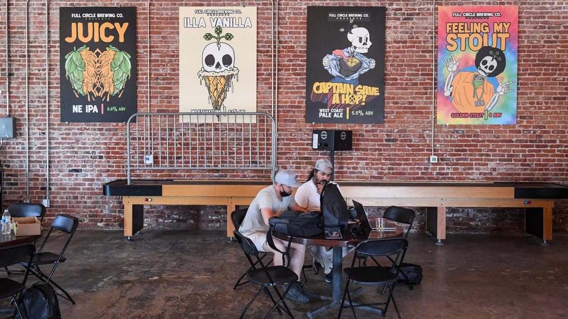 Posters of beer labels decorate the brick walls at Full Circle Brewing in downtown Fresno.