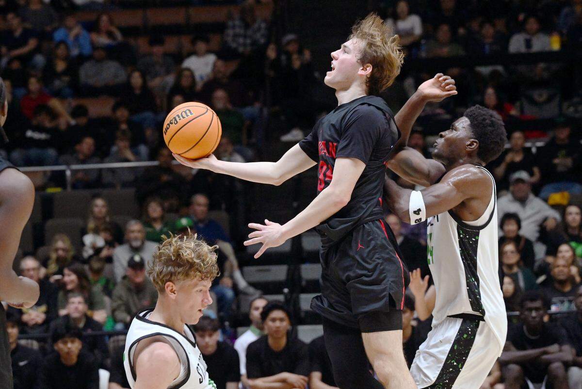 Buchanan’s Tyler Gibson, center, is fouled by St. Joseph in the CIF Division I Boys Basketball Championship Saturday, March 1, 2025 in Fresno.