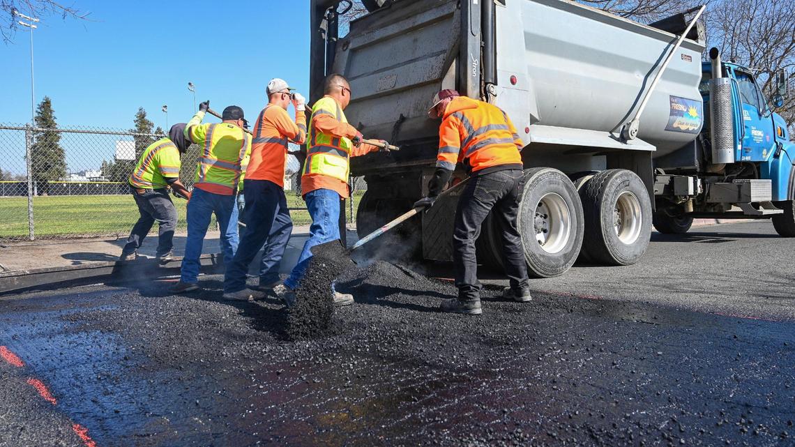 Fresno city work crews work to install a speed bump on Belgravia Avenue near Computech Middle School in Fresno on Monday, Feb. 7.