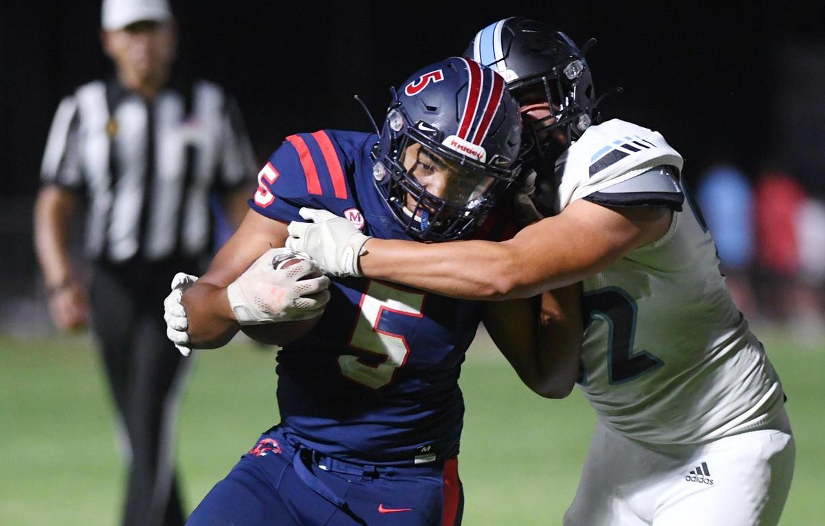 Clovis North’s Mario Gonzalez, right, tries to tackle San Joaquin Memorial’s Ty Morgan, left, Friday, Aug. 19, 2022 in Fresno.