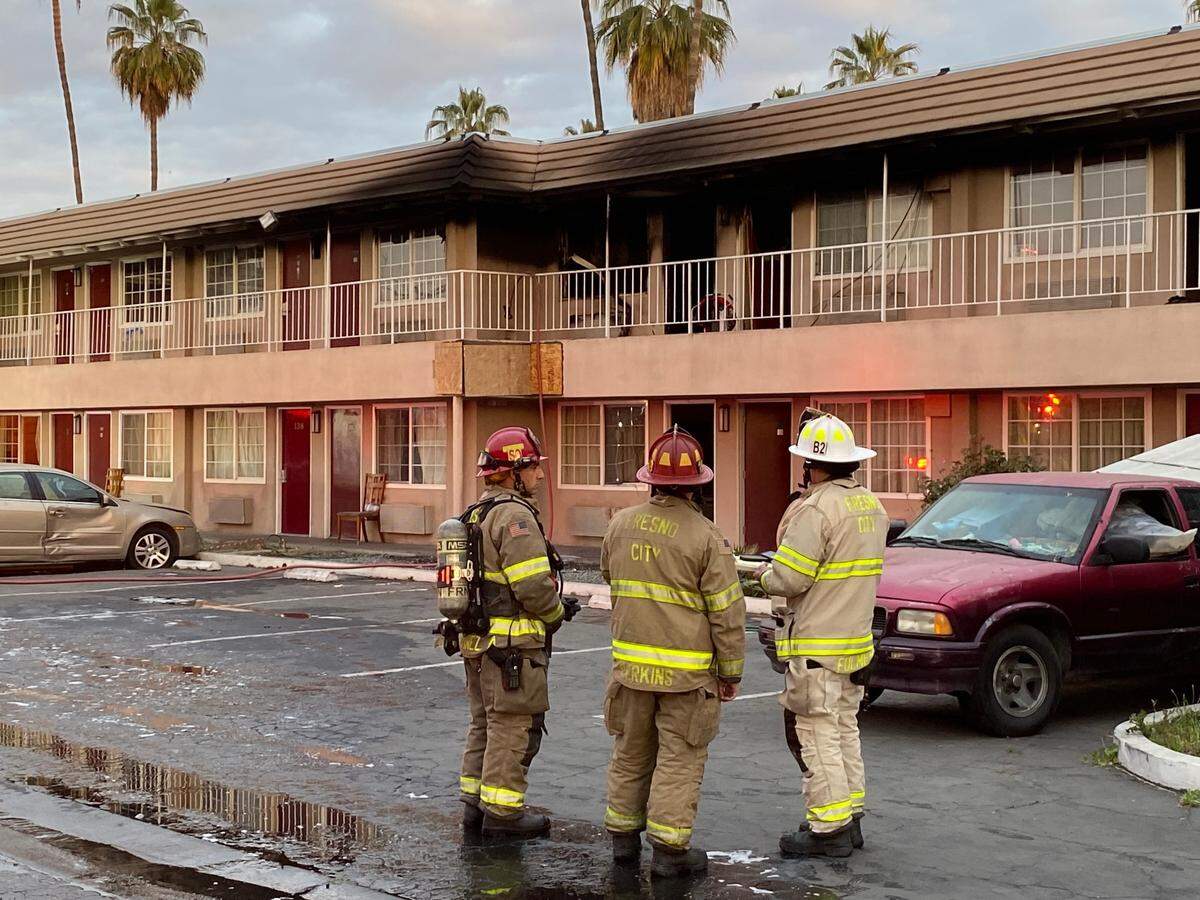 Firefighters survey the damage after a blaze at the former Days Inn in Fresno, California, on Tuesday, March 15, 2022.