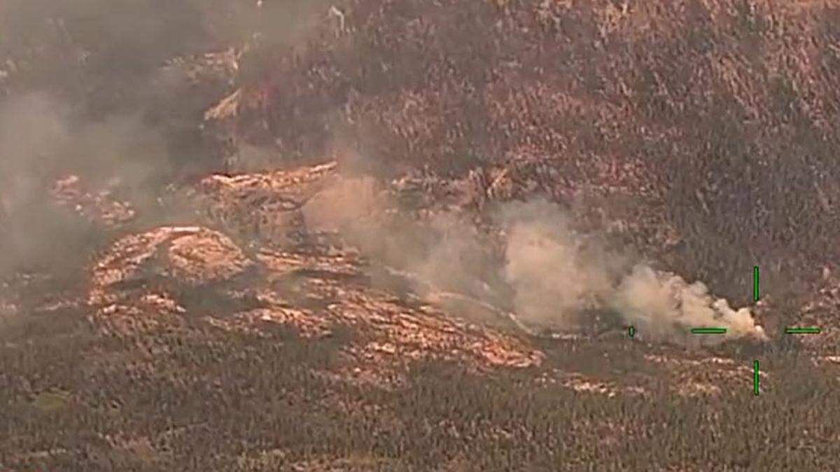 An aerial view of the Washburn Fire, looking south, shows prominent smoke rising from a hot spot along the south fork of the Merced River on July 17.