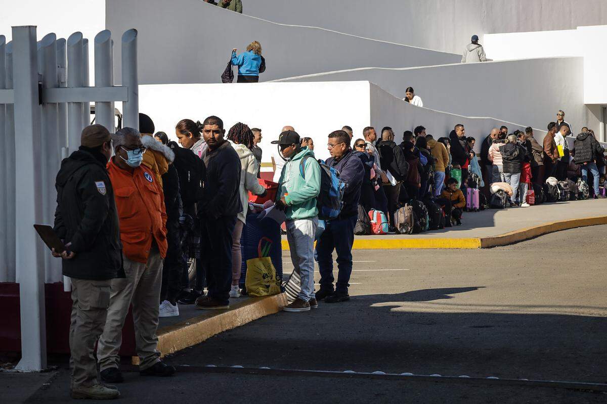 Migrantes hacen fila para solicitar un proceso de asilo en Estados Unidos, el 25 de enero de 2024 en el paso fronterizo del Chaparral en Baja California.