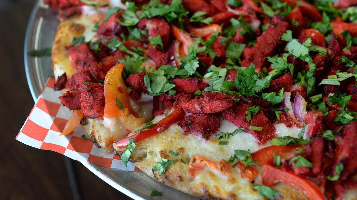 A tandoori chicken masala pizza is on the menu at the The Curry Pizza Company, which just opened a new location at Clinton and Blythe avenues.