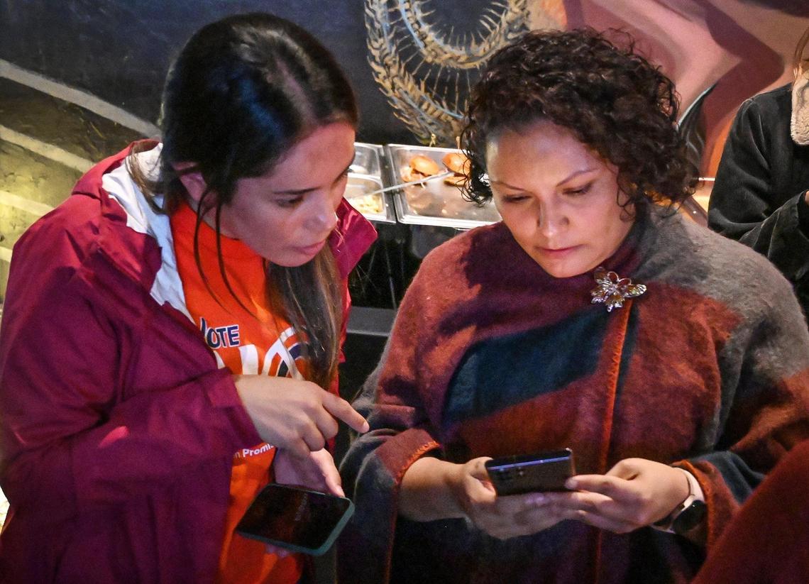 Veronica Garibay, left, co-director of Leadership Counsel for Justice and Accountability, and Sandra Celedon, CEO of Fresno Building Healthy Communities, check early election results while gathering with supporters who are against the renewal of Measure C during a election night watch party at Vibez Lounge in Fresno’s Tower District on Tuesday, Nov. 8, 2022.