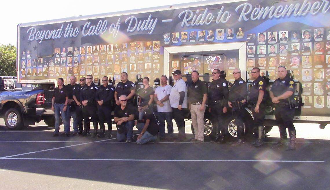 Fresno Police Department officers and Fresno County Sheriff’s deputies take a photo in front of the End of Watch Ride trailer displaying the names of officers, including two from the Fresno area, who died in 2020.