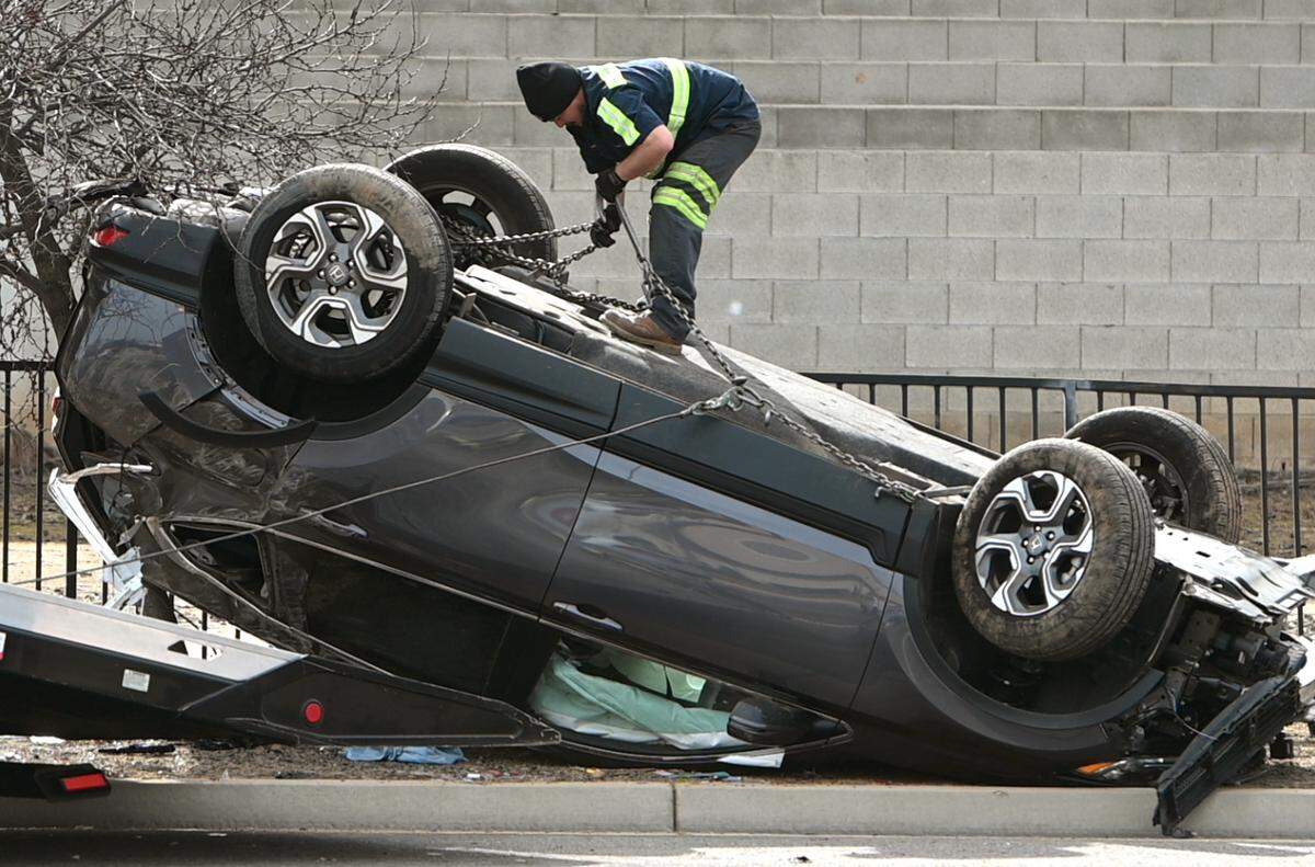 A tow truck driver works to right an overturned car on Herndon, west of Marks, Monday, Feb. 14, 2022. Power in the area was out after the car hit electrical wiring, police said.