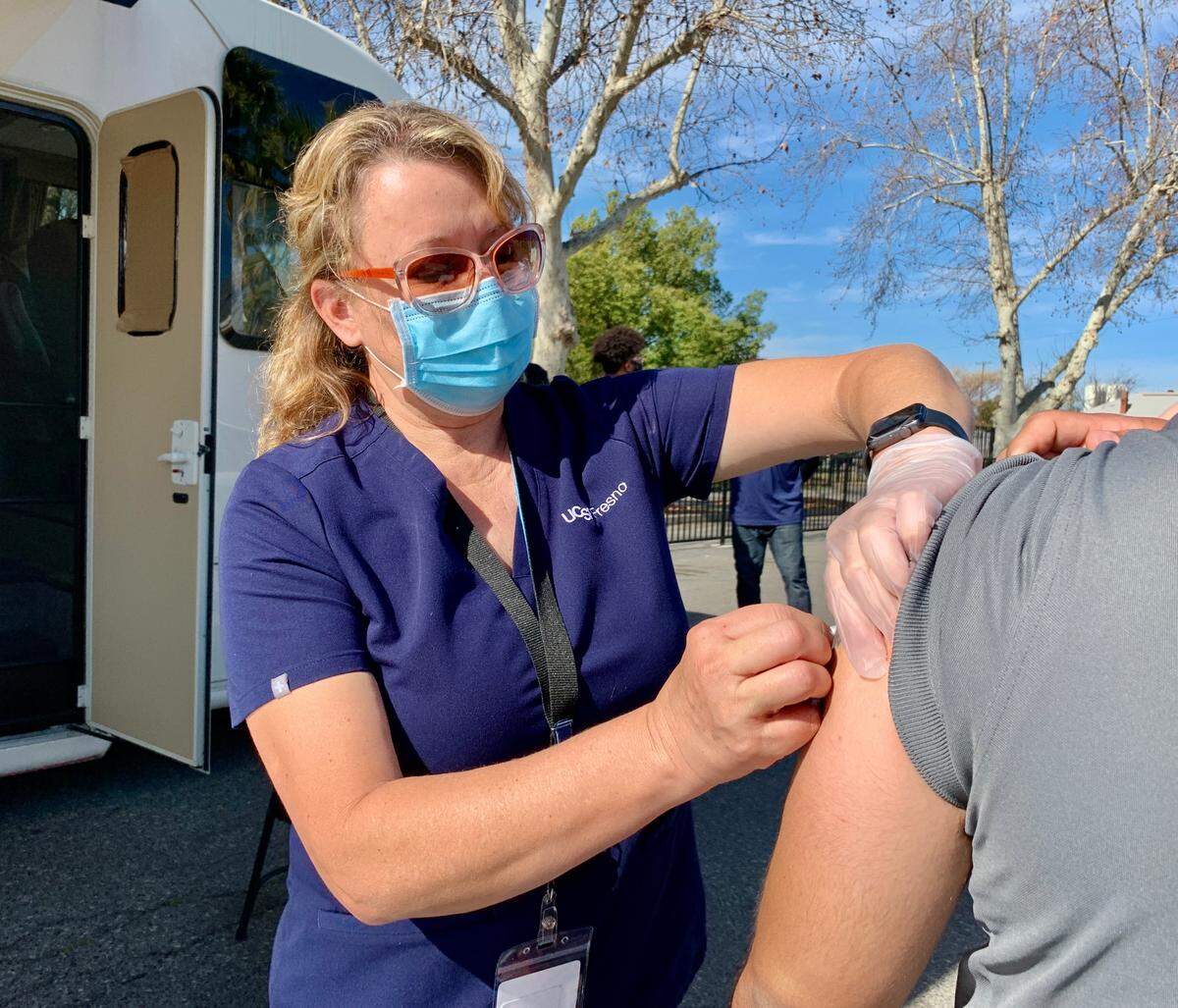 Jolene Woods an RN and UCSF Fresno COVID-19 Equity Project clinical manager, vaccinates a patient.