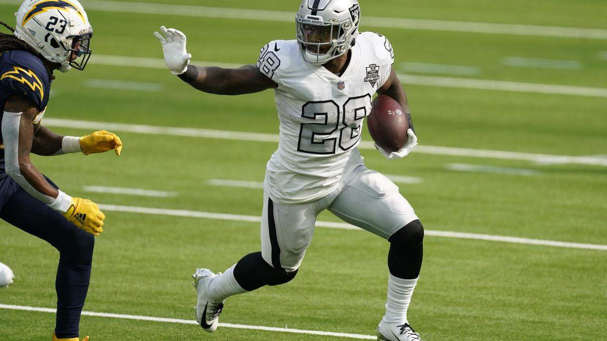 Las Vegas Raiders running back Josh Jacobs, right, runs with the ball during the first half of an NFL football game against the Los Angeles Chargers, Sunday, Nov. 8, 2020, in Inglewood, Calif.
