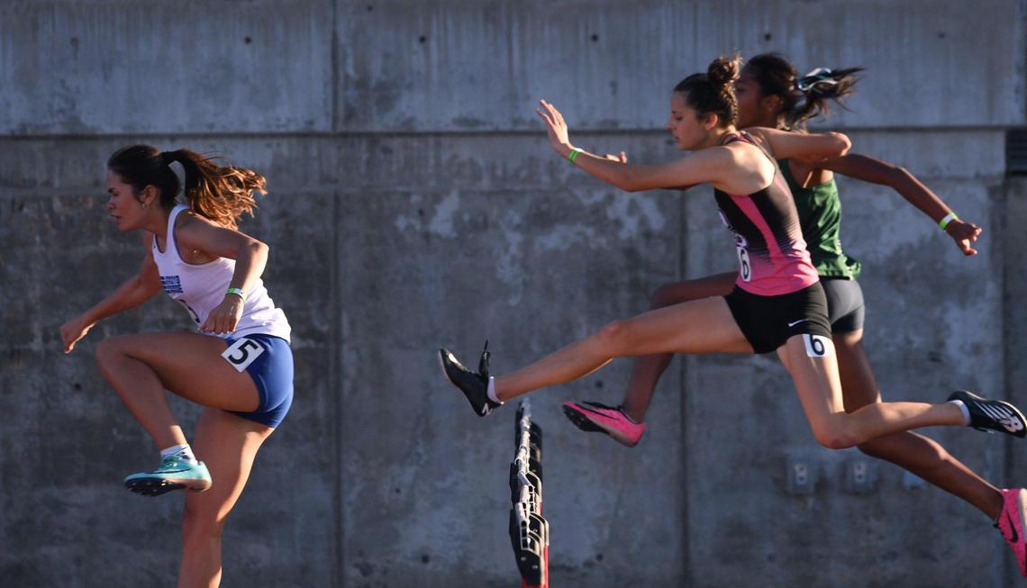 Central High’s Riley Costales, right, chases Arroyo Grande’s Daniela Rules, left, in the 300 hurdles at the Central Section Masters held at Buchanan High School Saturday, May 21, 2022 in Clovis.