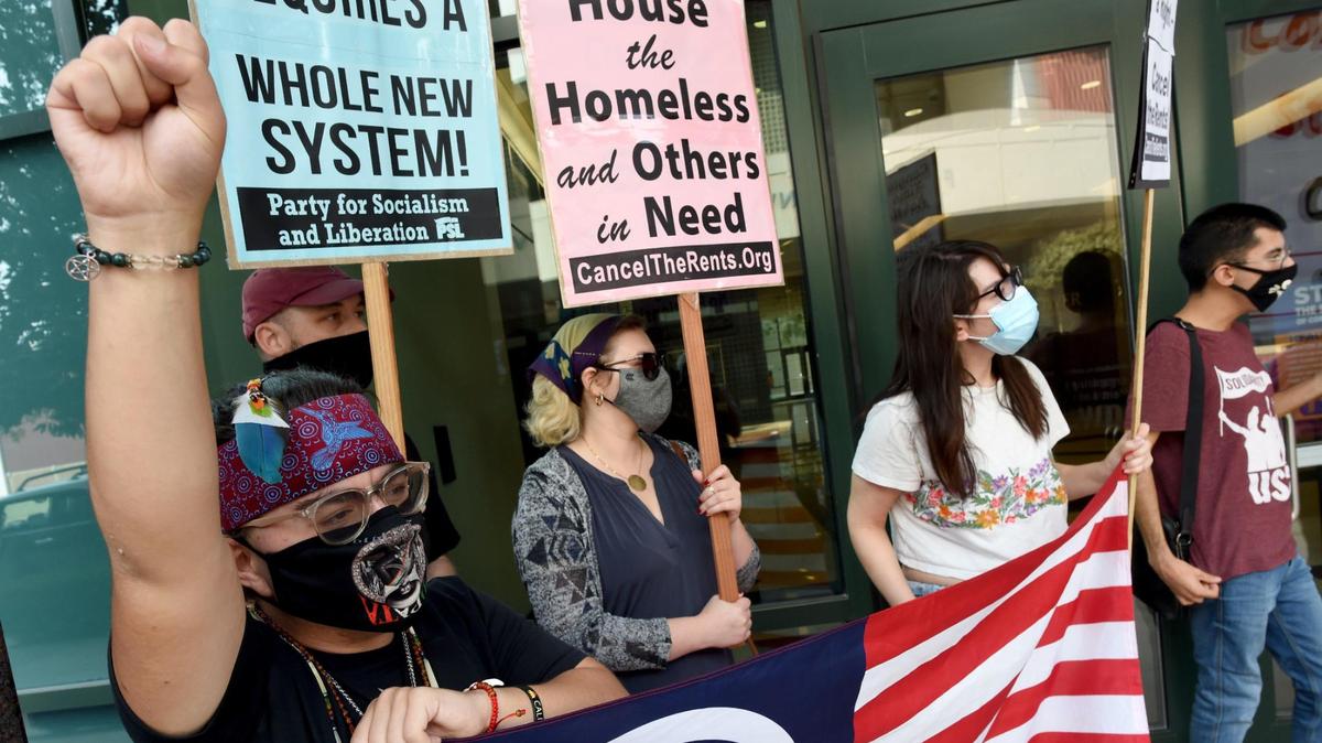Ronnie Kassis of Fresno, left, joins with other housing rights activists during the Stop All Evictions! protest Saturday Sept. 25, 2021, in front of Rep. Jim Costa’s office.