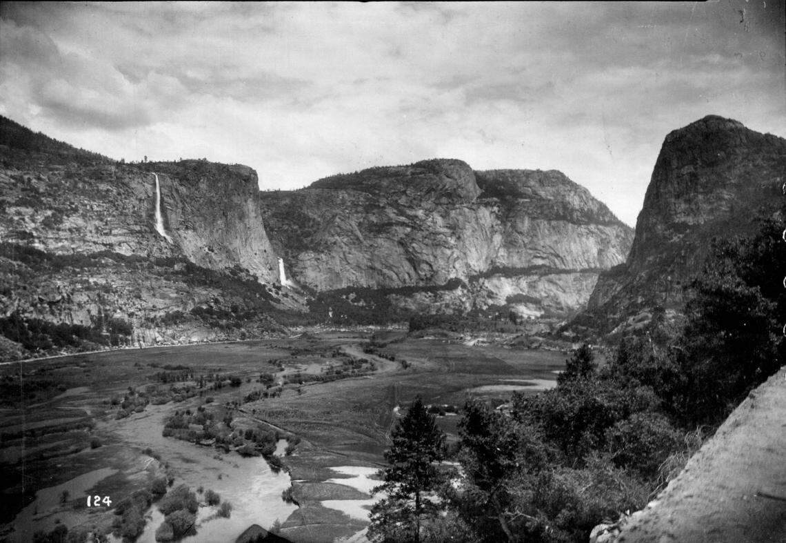 A photo of Hetch Hetchy Valley before it was dammed reveals a broad valley of the Tuolumne River.