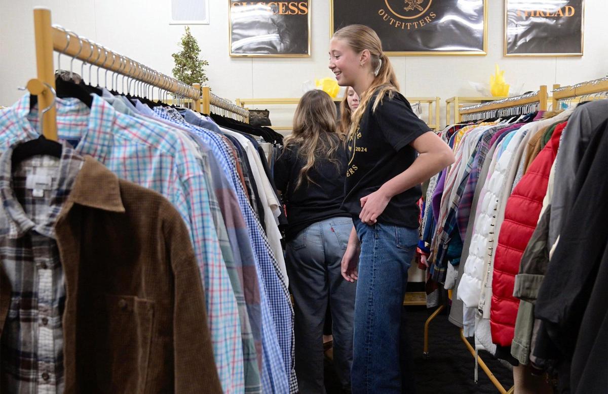 Marketing Ambassador Kennedy Morrow, center, peruses the clothing after the grand opening of Clovis West’s new student store Golden Eagle Outfitters Thursday afternoon, Jan. 30, 2025 in Fresno. The store receives donated new and almost-new clothing for students, inspired by a past student’s need.