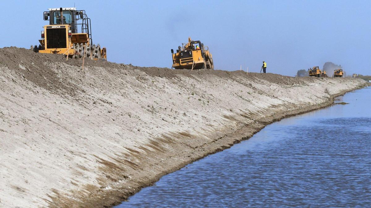 Maquinaria pesada ayudar a elevar más de tres pies el dique al sur de Corcoran, en la tarde del martes 25 de abril de 2023, justo al sur de Corcoran, CA.