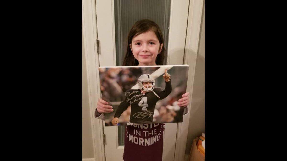 Brooklyn Reiter of Myrle Beach, S.C., holds up a signed autograph picture from Derek Carr last week, and also received a letter with words of encouragement from Carr. Reiter has an incurable brain condition called hydrocephalus and has undergone eight surgeries.